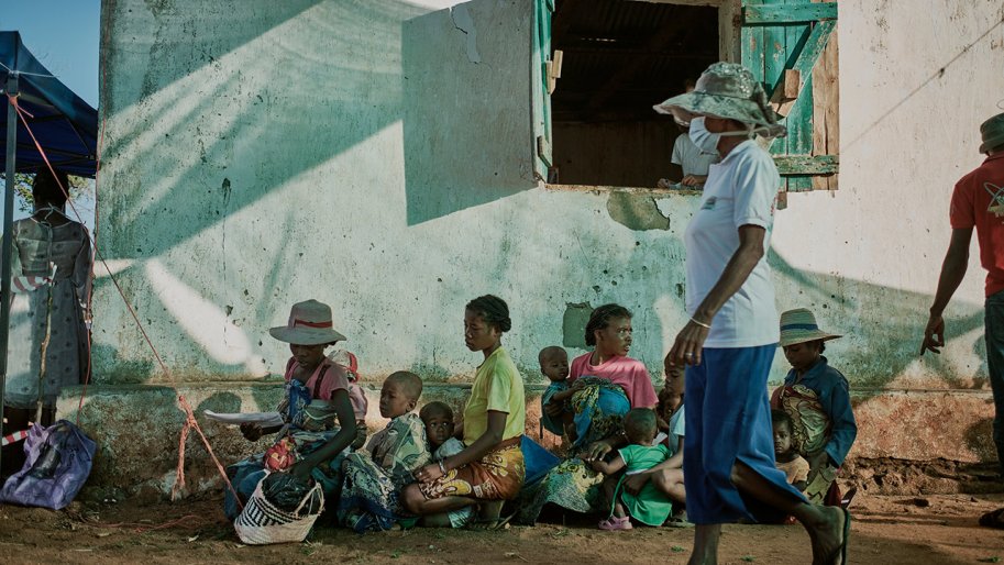 Familles assises par terre devant le mur de la clinique MSF