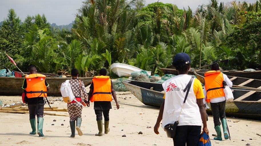 Une équipe MSF marche sur le sable pour atteindre le village d'Enyenge où ils mènent le deuxième jour de la campagne de vaccination contre le choléra. Enyenge, Sud-Ouest du Cameroun, 17 février 2022