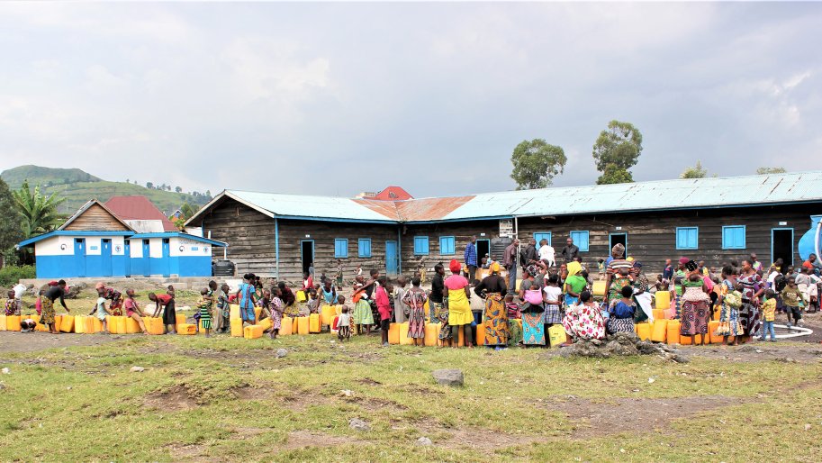 Des familles font la queue pour recevoir de l'eau potable distribuée par MSF.