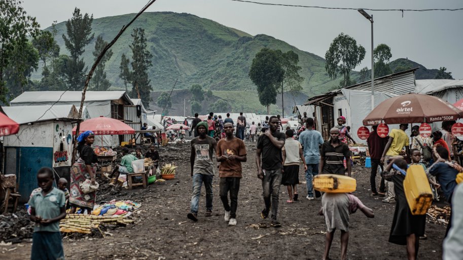 Menschen im Geflüchtetencamp Kashaka westlich von Goma tragen Wasserkanister.