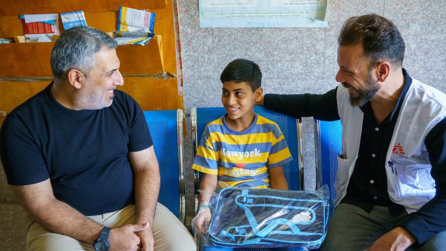 Abu Al-Fadl, un jeune garçon chez qui une tuberculose a été diagnostiquée très tôt, est assis avec son père et un agent de promotion de la santé de MSF au centre de santé Mustafa Al-Adhari, à Sadr City.