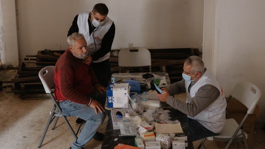 Libanon, Beirut, 2026. Ein Arzt hört mit einem Stethoskop die Atmung eines Vertriebenen ab, während eine Krankenschwester von „Ärzte ohne Grenzen“ seine Vitalwerte aufzeichnet.