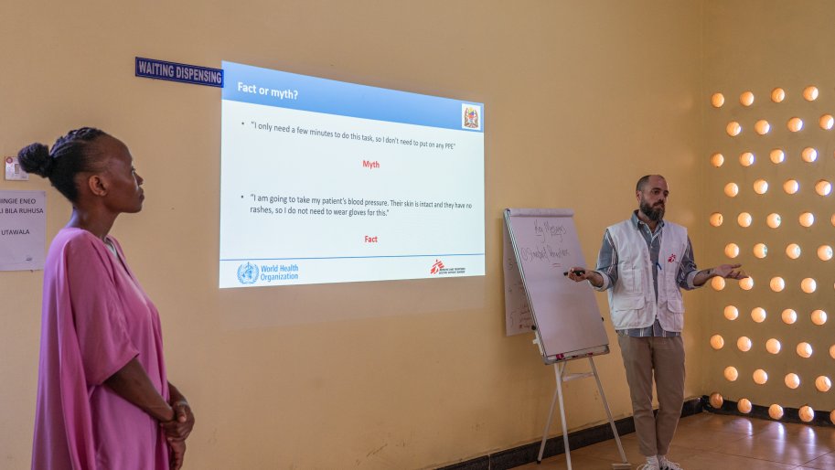 During a full day of training by MSF technical experts at the Marburg treatment unit, Anthony Twyman, MSF infection prevention and control manager, with the help of Jackline John Ngelela, MSF translator, explains key IPC pillars and the behaviour to adopt in order to avoid contamination in the health centres where the participants to the training work. 