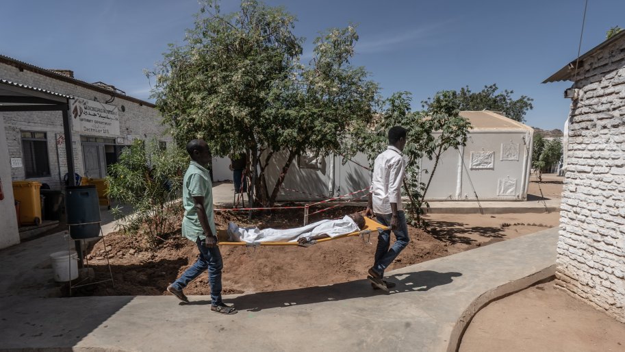 Deux membres du personnel médical de MSF transportent un jeune garçon sur une civière depuis le bloc opératoire vers l'unité de soins intensifs de l'hôpital de Paris géré par MSF à Tawila