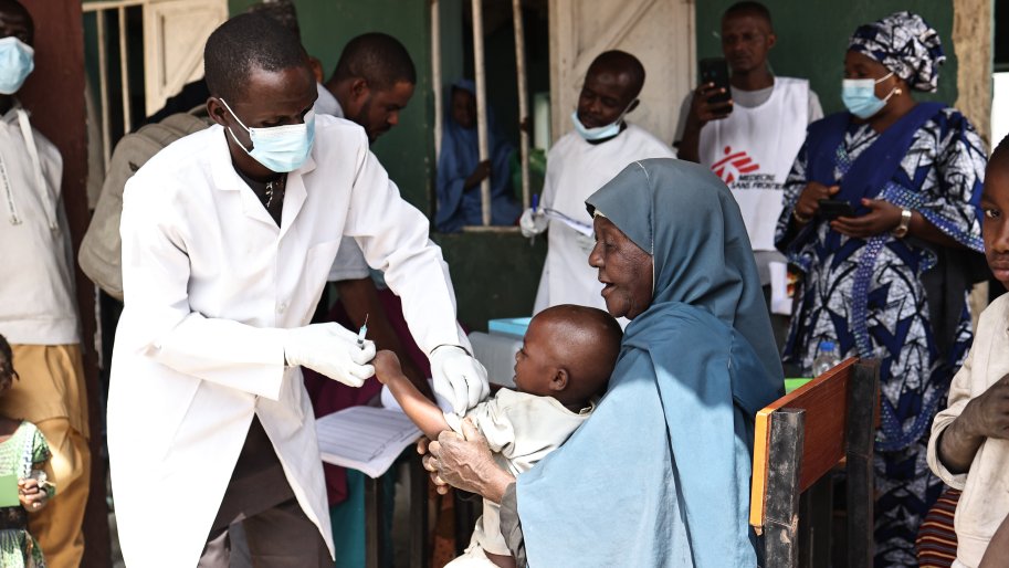 Un garçon, tenu par son accompagnateur, reçoit une dose de vaccin contre la diphtérie dans une école primaire de la ville de Durum, dans le quartier de Kundun Durum, lors d'une campagne de vaccination contre la diphtérie menée par le ministère de la Santé de l'État en collaboration avec MSF dans l'État de Bauchi, au nord-est du Nigeria. 