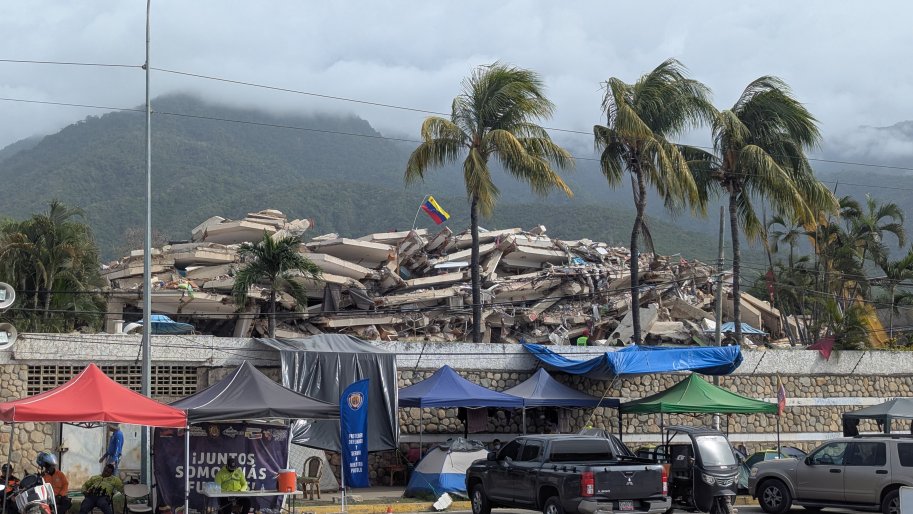 Le drapeau vénézuélien flotte au-dessus des décombres d'un immeuble effondré à La Guaira, ce mardi 21 juillet 2026. Cette région côtière est la plus touchée par les récents séismes dévastateurs.