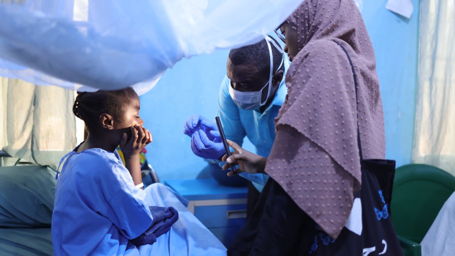 Un chirurgien du ministère de la Santé et un kinésithérapeute de Médecins Sans Frontières (MSF) examinent Maryam Bashir, âgée de 12 ans, trois jours après qu’elle a subi une intervention de chirurgie reconstructive du nez à l’hôpital pour enfants de Noma, soutenu par MSF, dans l’État de Sokoto, au Nigeria.