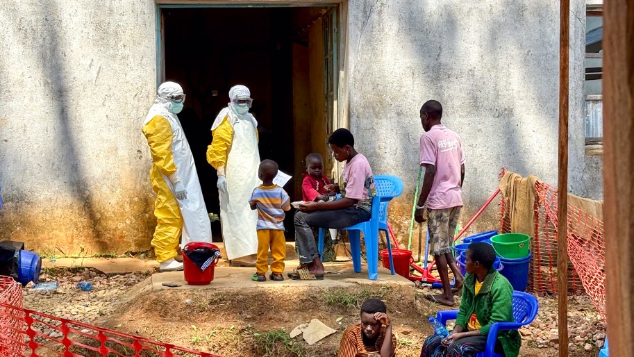 Deux professionnels de santé s'entretiennent avec des patients hospitalisés pour un cas confirmé d'Ebola.