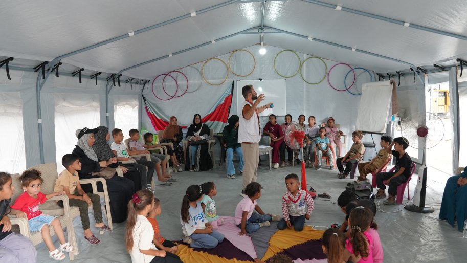 Mahmoud Al-Balbisi, conseiller en santé mentale chez Médecins Sans Frontières (MSF), anime une séance ludique et pédagogique destinée aux enfants et à leurs accompagnants à l'intérieur d'une des tentes du poste de soins.