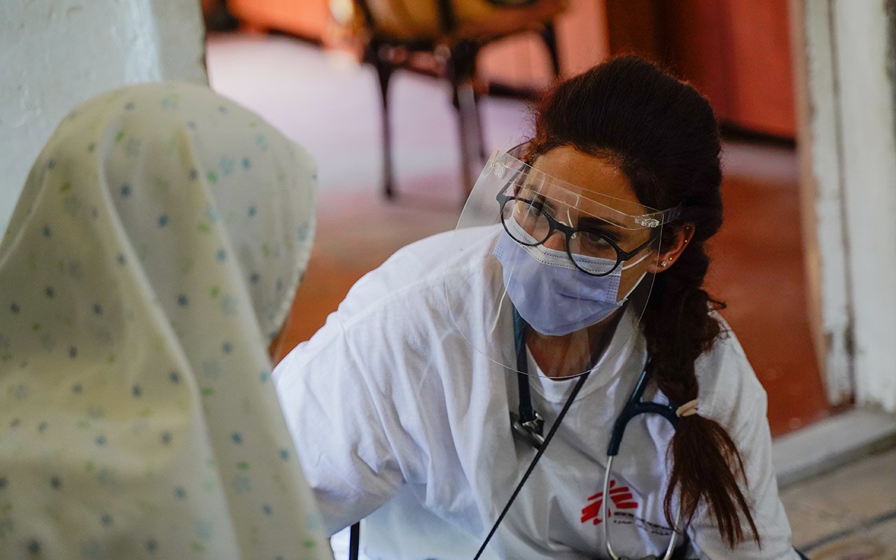 Une médecin avec sa visière protectrice inspecte une patiente à Beyrouth