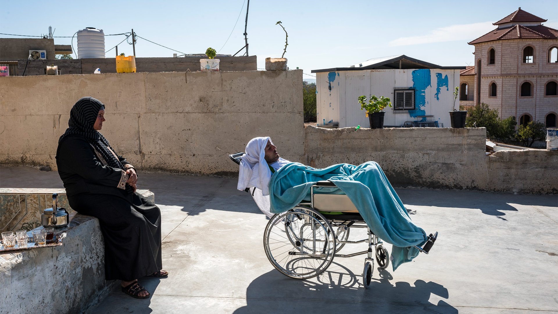 Haroon dans son fauteuil, accompagné de sa mère Farisah.