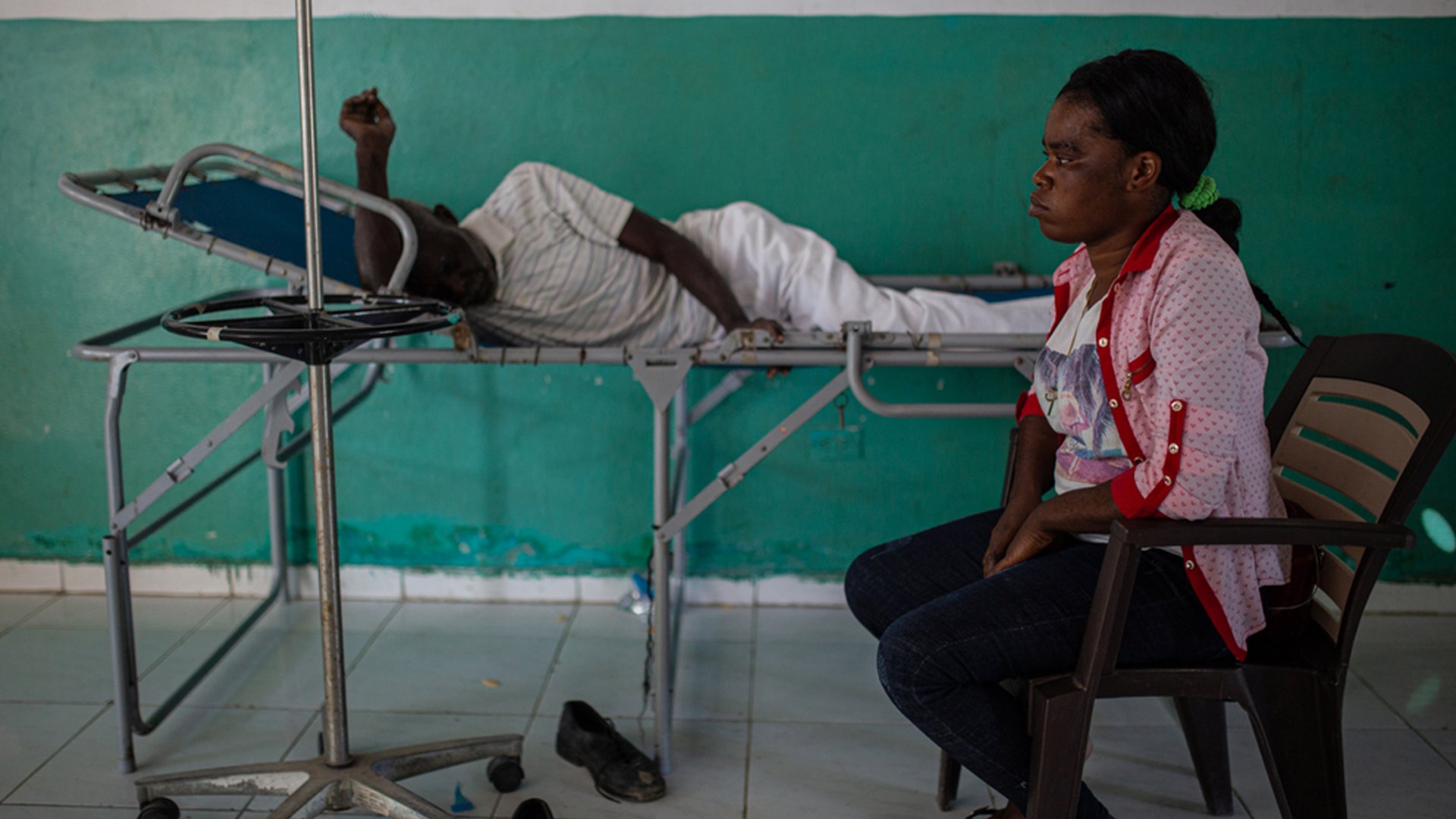 Tochter wartet mit ihrem verletzten Vater. Port-au-Prince, Haiti, Dezember 2022.