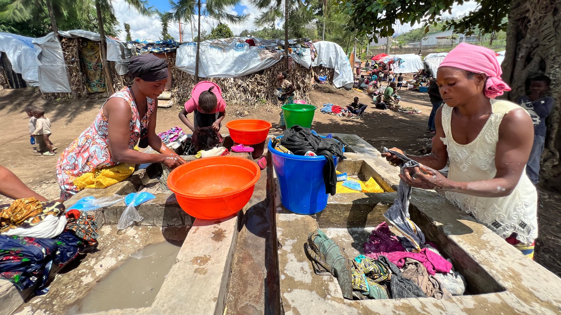 Frauen waschen Kleider in einem Geflüchtetencamp. DR Kongo, Mai 2023.