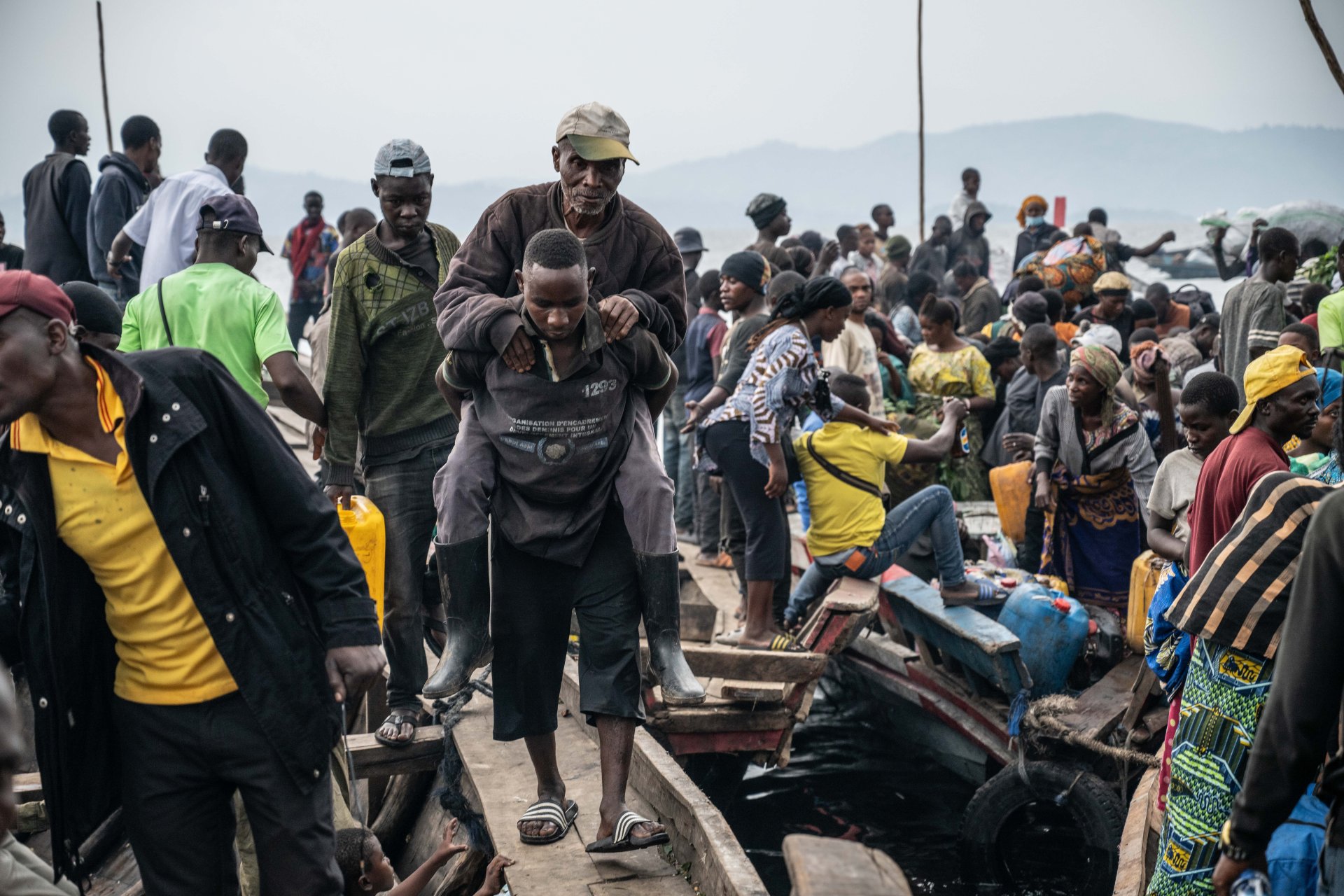 Des personnes fuyant les combats arrivant au port de Kituku, à Goma.