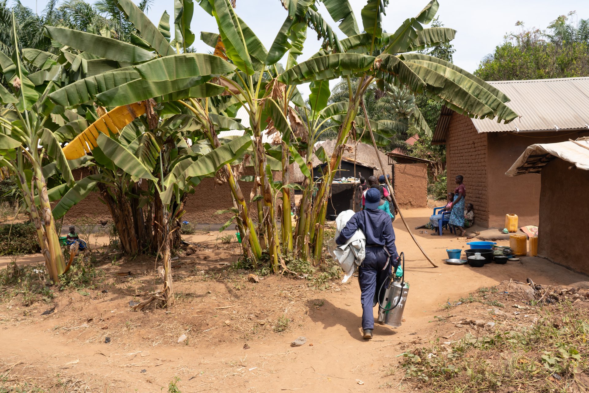 Une femme se déplaçant avec un pulvérisateur à insecticide.