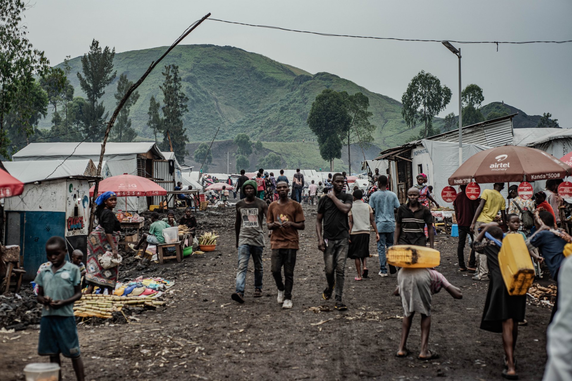 Des personnes vivant dans le camp de déplacés de Kashaka, à l’ouest de Goma, transportent des bidons d’eau.