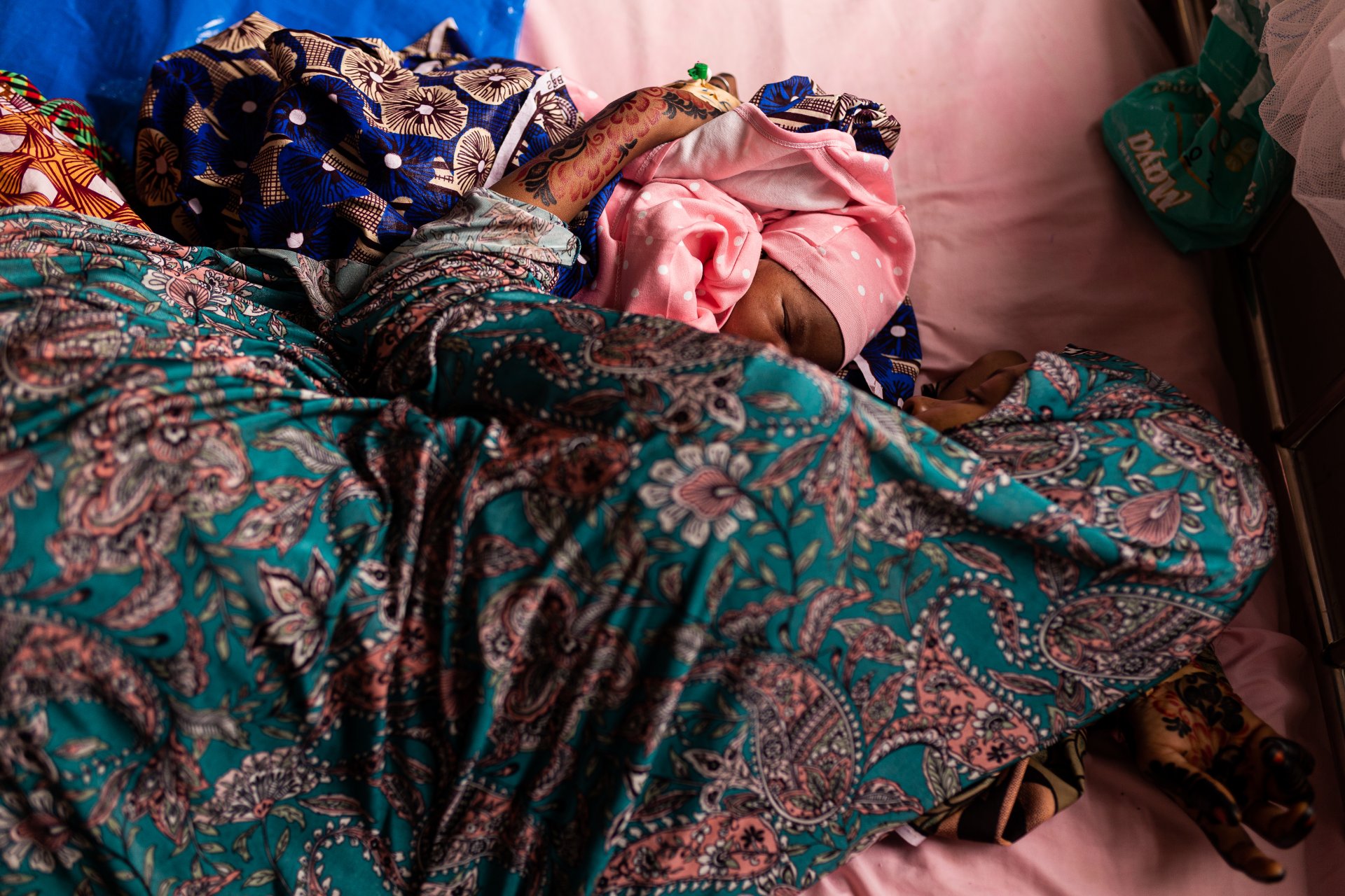 Amina Tahila (27 ans), jeune maman, est allongée dans son lit avec son bébé et le kit gratuit de soins postnatals (appelé « Mama package ») fourni par MSF aux nouvelles mères qui accouchent à l'hôpital général de Shinkafi.