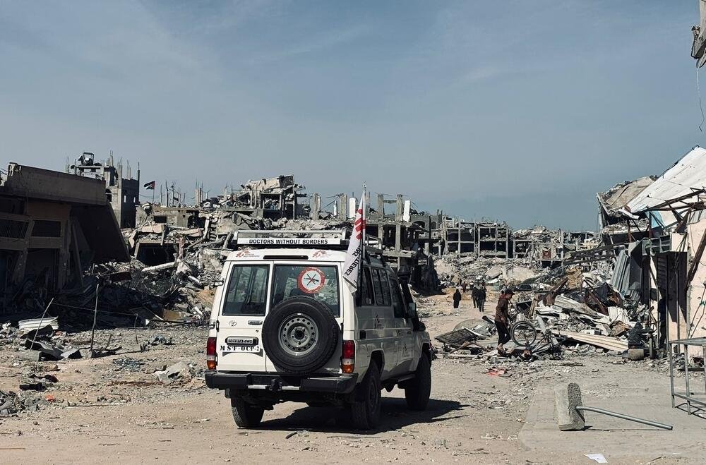 An MSF vehicle passes in front of ruined buildings in Jabalia. Palestine, February 2025.