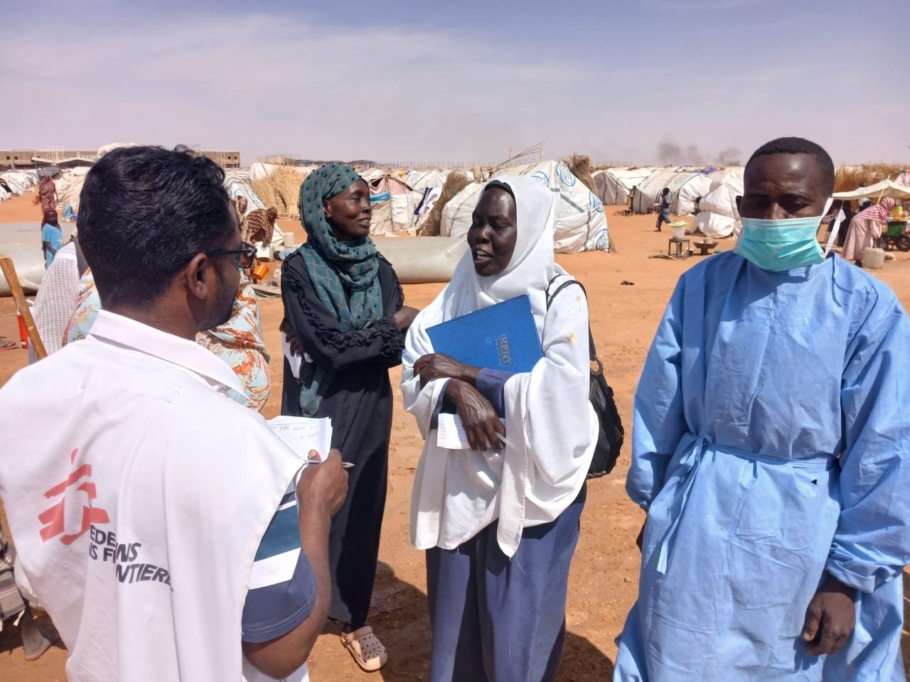 Un membre du personnel de MSF discute avec une femme à Al Mina Al Muwahad, le plus grand camp de déplacés près de la ville d'El Obeid.