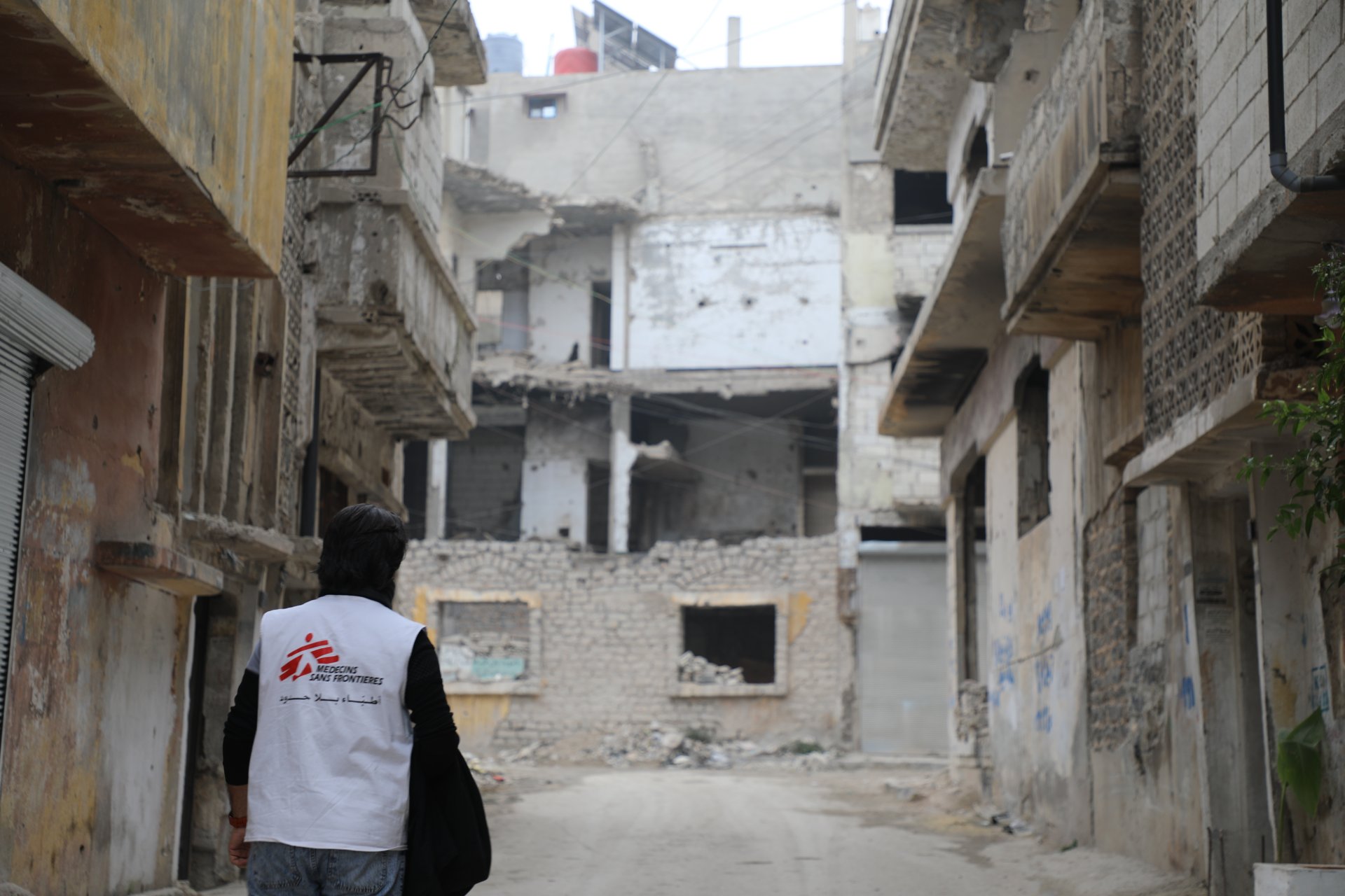 Une infirmière de MSF se promène en contemplant l'étendue des dégâts dans le quartier d'Al-Khalediya, à Homs.