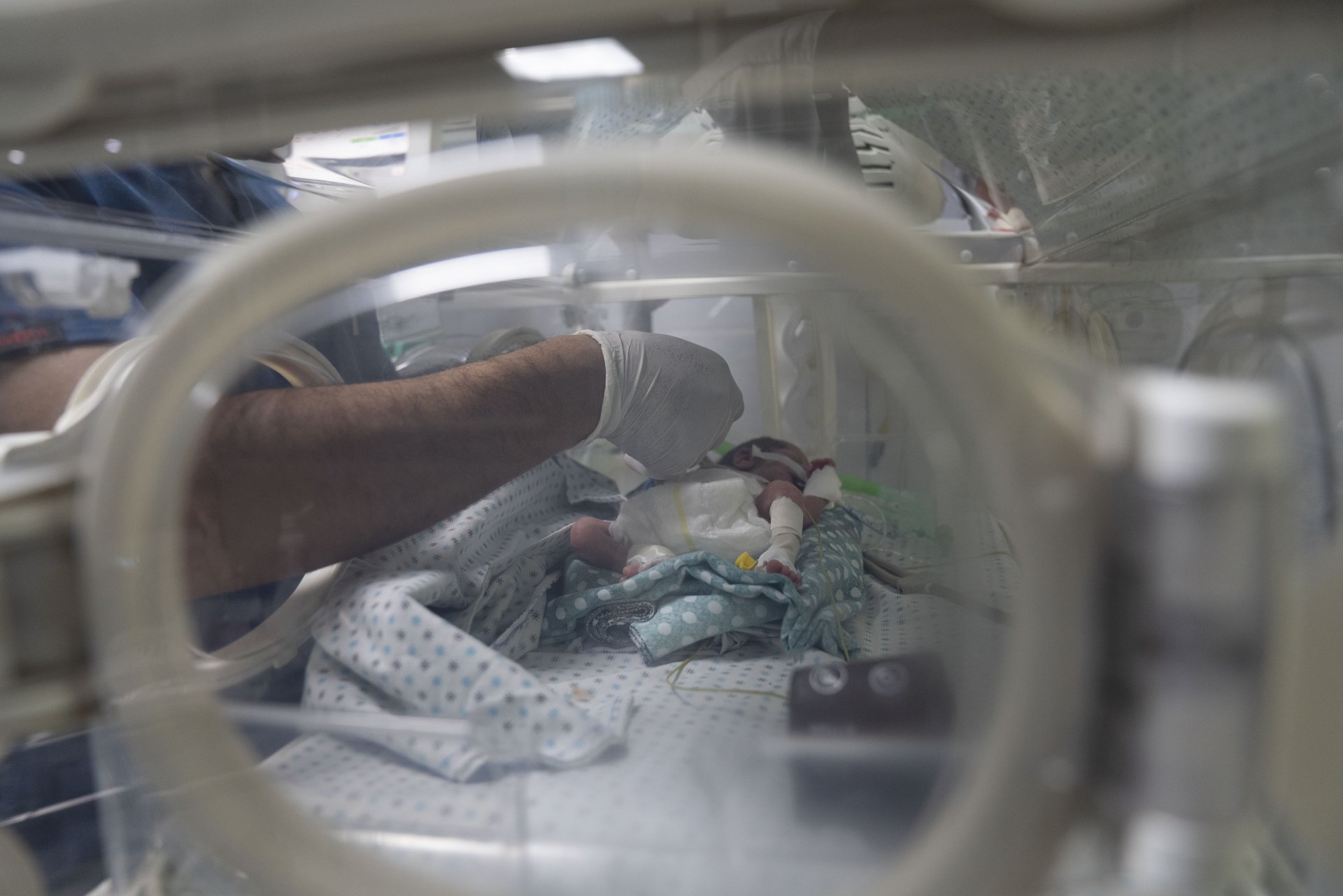 Ein Mitarbeiter des Al-Helou-Krankenhauses in Gaza in den besetzten palästinensischen Gebieten kümmert sich um ein untergewichtiges Neugeborenes, das in einem Inkubator liegt. 