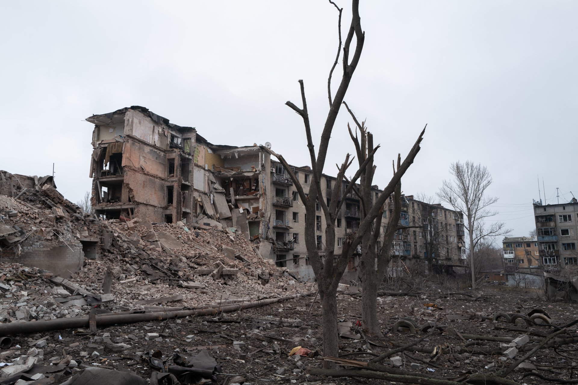 Am 3. Dezember 2025 ragen in Kostiantynivka in der Ukraine entwurzelte Bäume inmitten der Trümmer eines zerstörten Wohnhauses empor.