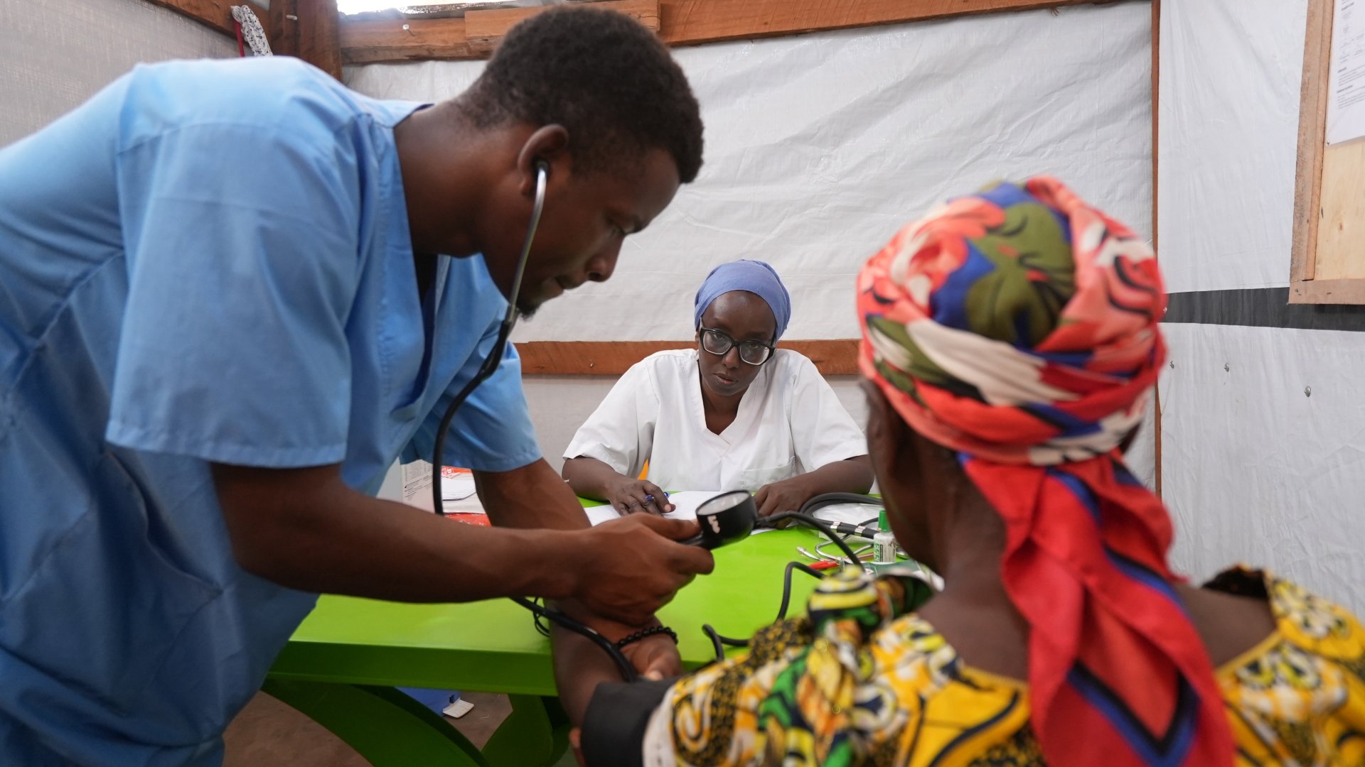 Au centre de santé de MSF, dans le camp de réfugiés de Busuma, des équipes médicales examinent un jeune patient accompagné de sa mère dans la salle de consultation