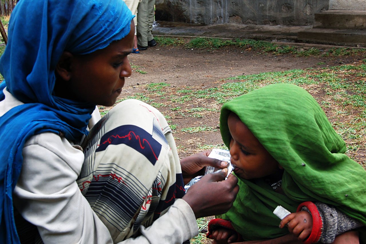 Une jeune fille nourrit sa petite soeur avec de l'alimentation thérapeutique Plumpy'nut à Shalla (Aje), Oromiya la région, Ethiopie du sud. 