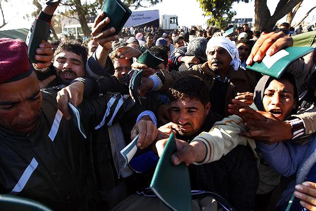 Après avoir traversé la frontière de Ras Jdir, des réfugiés égyptiens ayant fuit la Libye tentent de se faire enregistrer dans un camp de réfugié. Tunisie, 25.02.2011