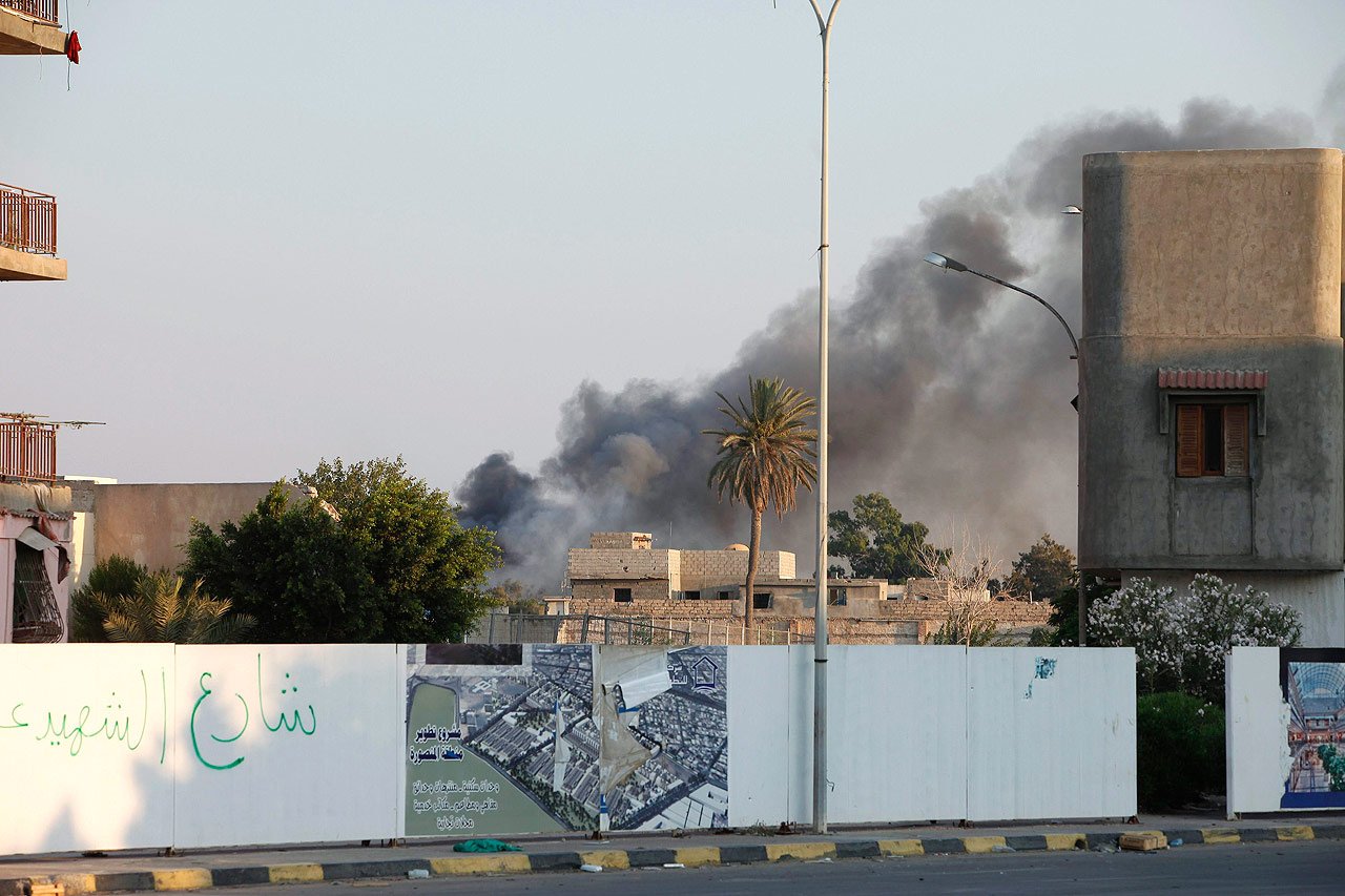 Des nuages de fumes apparaissent du complexe de Bab al-Aziziyah suite aux combats entre les rebelles et les force de Gaddafi à Tripoli.
