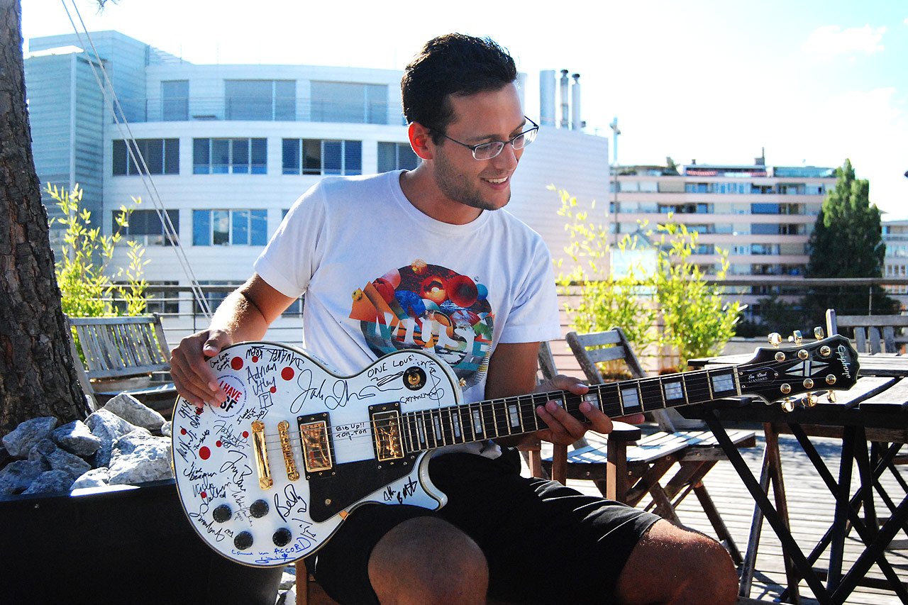 Le gagnant du concours MSF et la guitare dédicacée par les artistes présents sur la Grande Scène.