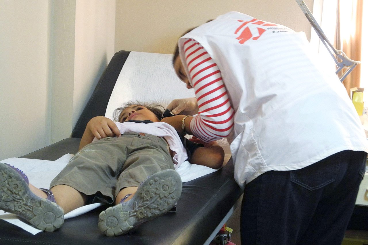 Un médecin MSF examine une réfugiée syrienne qui souffre de vomissements et de douleur à l’estomac.