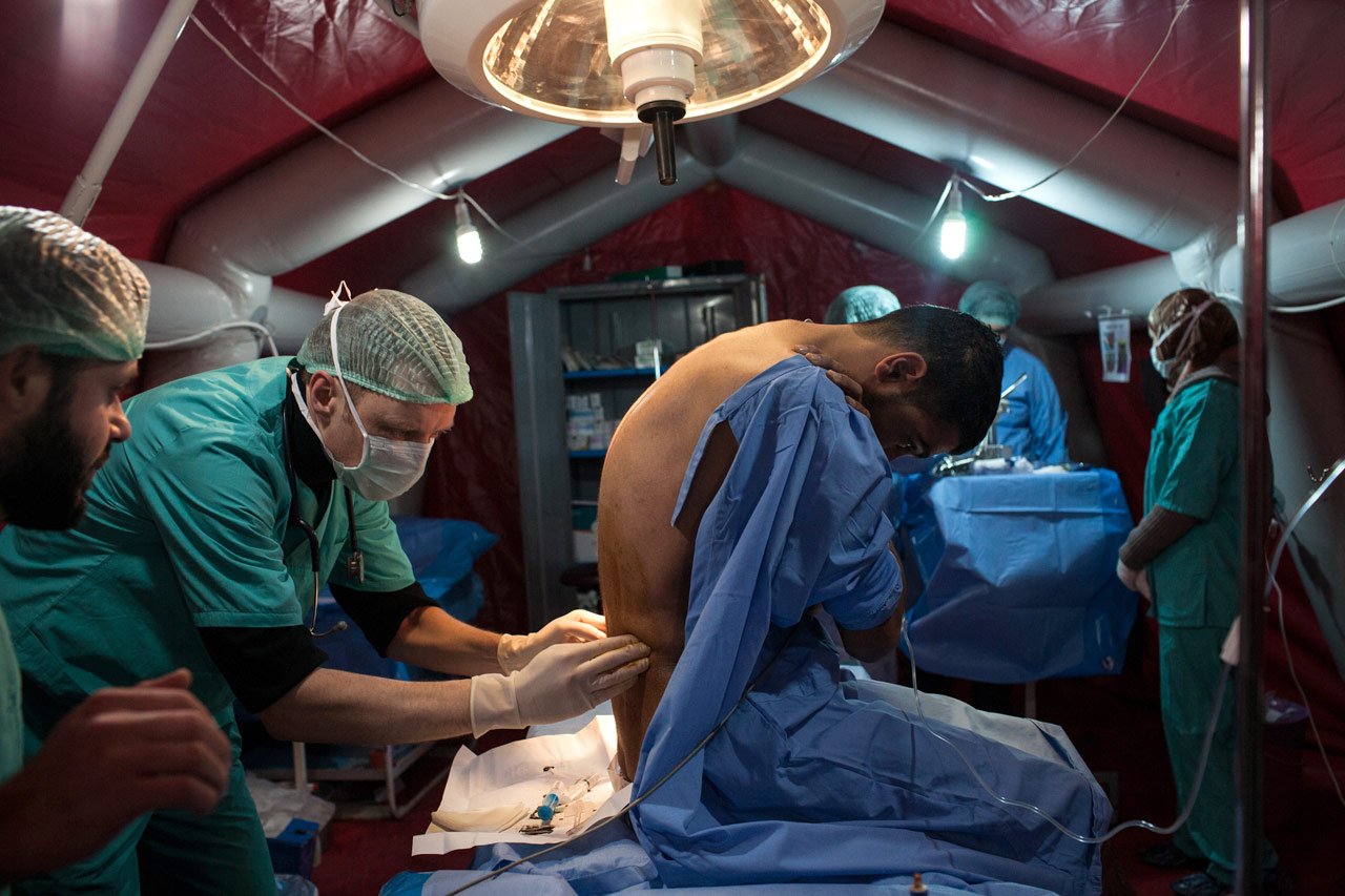 Un patient blessé par balle est examiné avant de subir une intervention chirurgicale en Syrie.