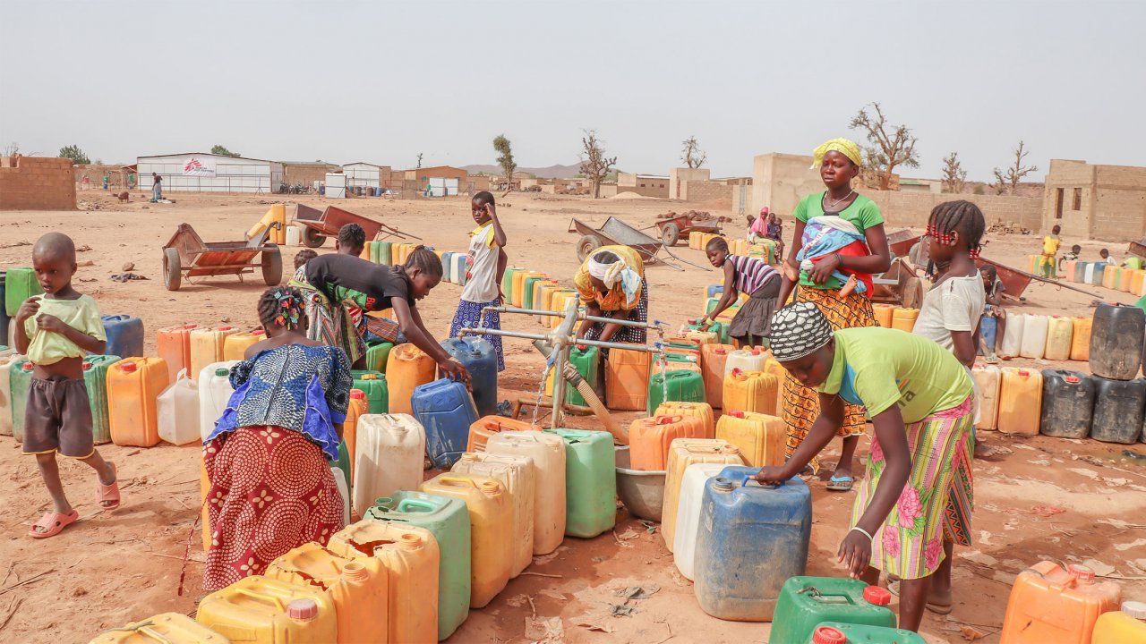 Des femmes prennent de l’eau au point d’eau du site de Kongoussi à l’aide de bidon en plastique.