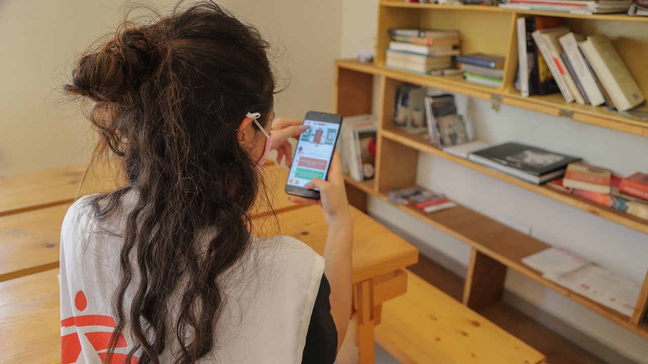 Eine Person aus dem MSF-Team testet die Covi-19-App auf ihrem Handy.