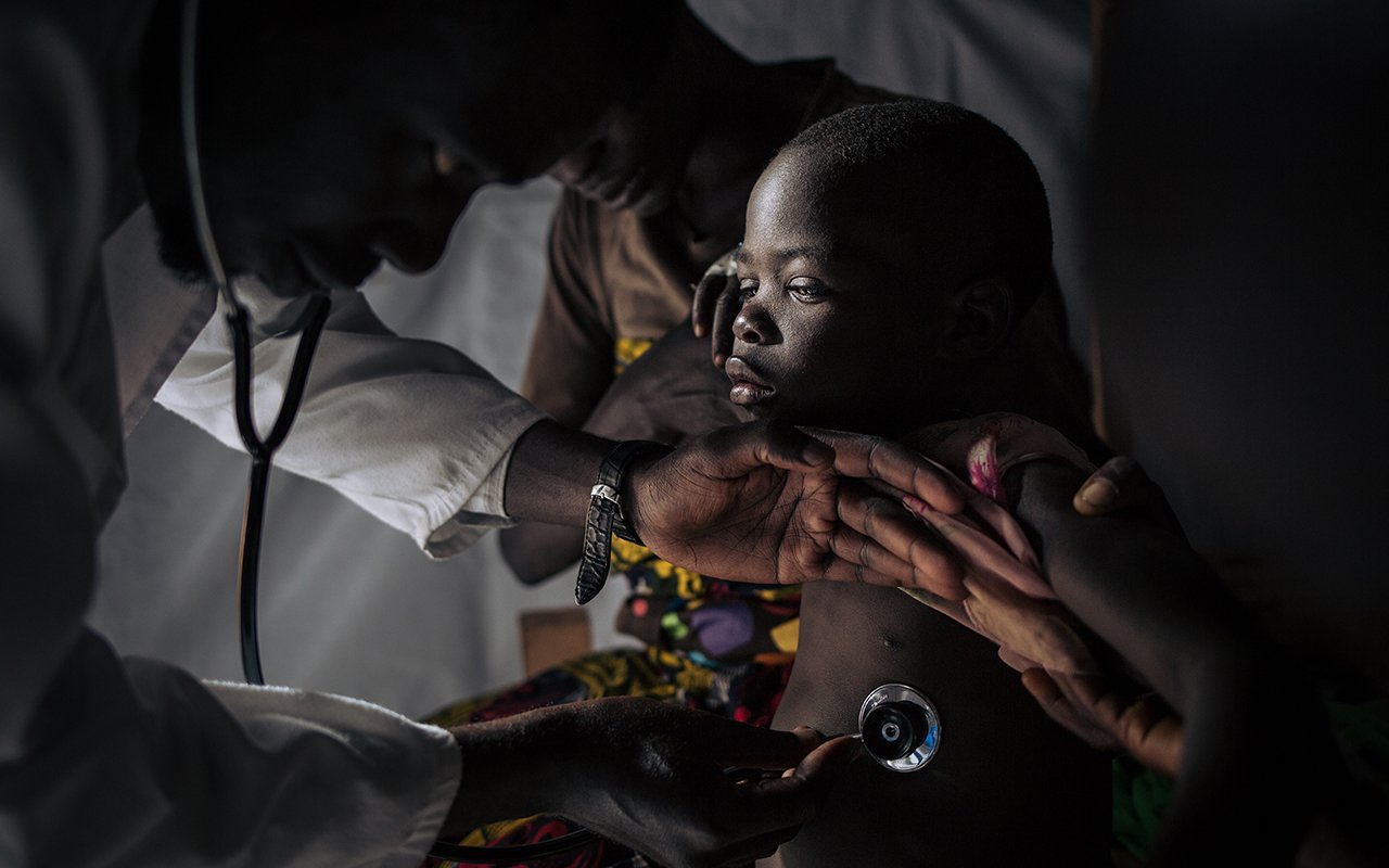Un docteur ausculte un enfant, stéthoscope en main