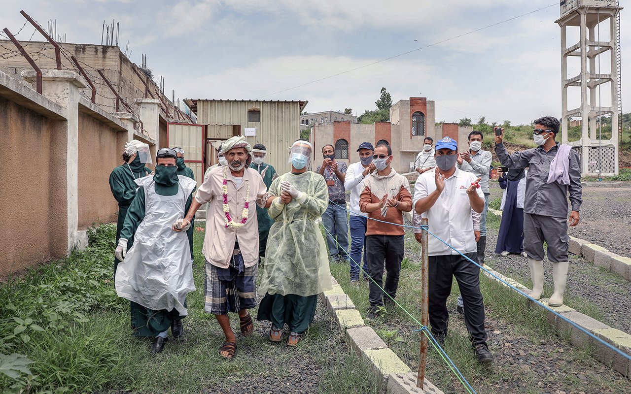 Un patient accompagné de personnel MSF en PPE