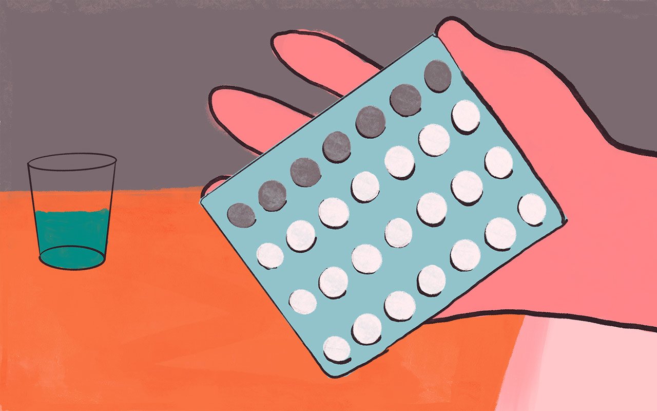 Main d'une femme tenant une plaquette de pilules contraceptives orales.