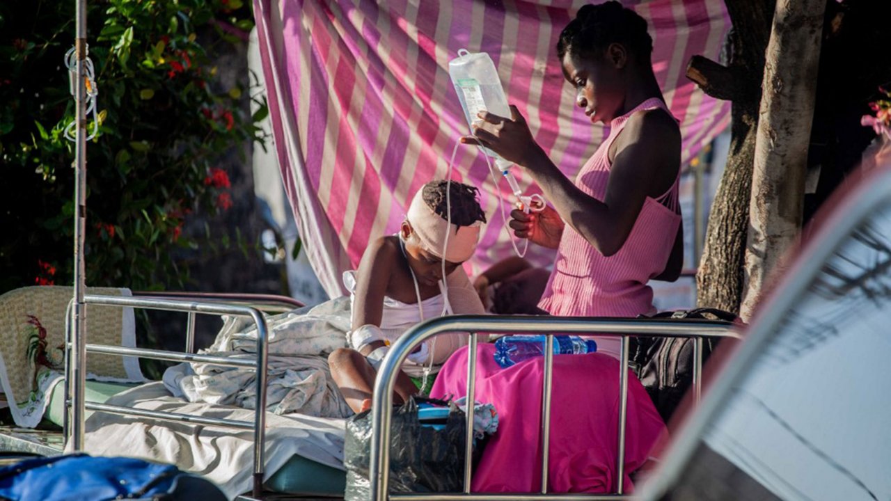 Un garçon est soigné à l'extérieur de l'hôpital général des Cayes, après un tremblement de terre de magnitude 7,2, le 15 août 2021 aux Cayes, en Haïti.