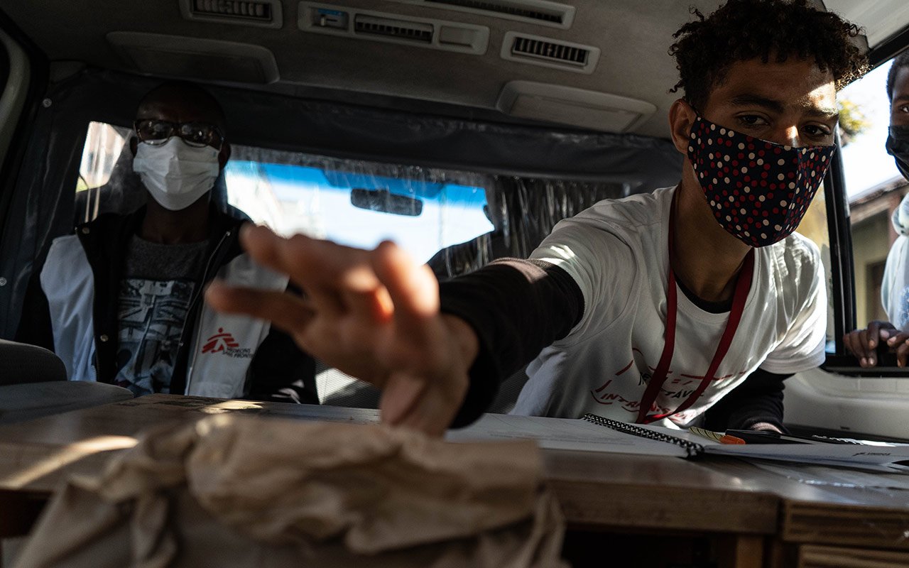 Carlos, ein Sozialarbeiter des MSF-Programms für Drogenkonsument:innen, nimmt ein abgepacktes Injektionsset entgegen. Die Kits werden im Rahmen des Programms zur Schadensminderung an Drogenkonsument:innen verteilt.