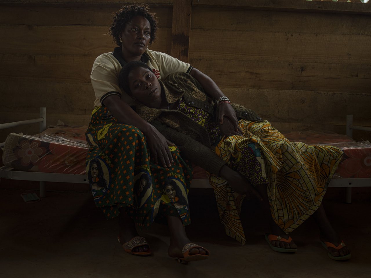 Nzale, 30 ans, allongée sur les genoux d'Honorine, 48 ans. Honorine est une soignante chargée de donner les premiers soins et un soutien psychologique aux femmes victimes de viol. Nzale a été abusée par des rebelles alors qu'elle cherchait de la nourriture pour ses sept enfants et qu’elle n’avait pas l’argent que ses agresseurs lui réclamaient.