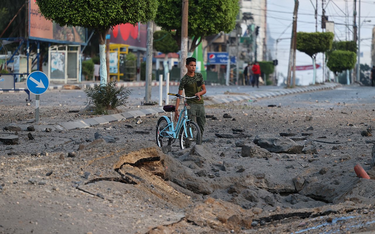 Homme avec son vélo dans une rue en ruine
