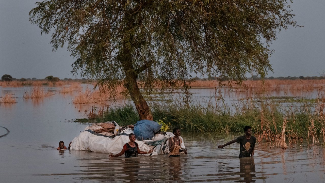 Nyataba et sa famille marche dans un paysage inondé.