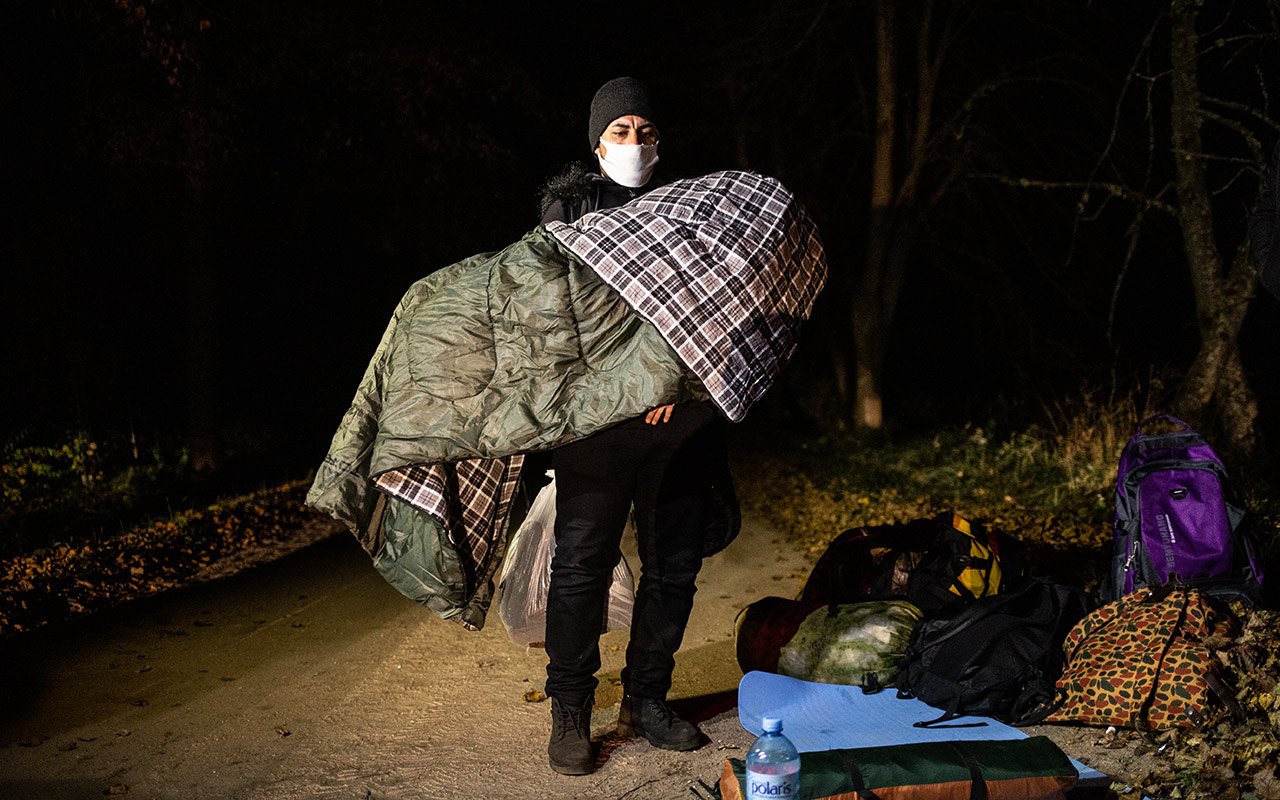 Père tenant son enfant emmitouflé dans des couvertures.