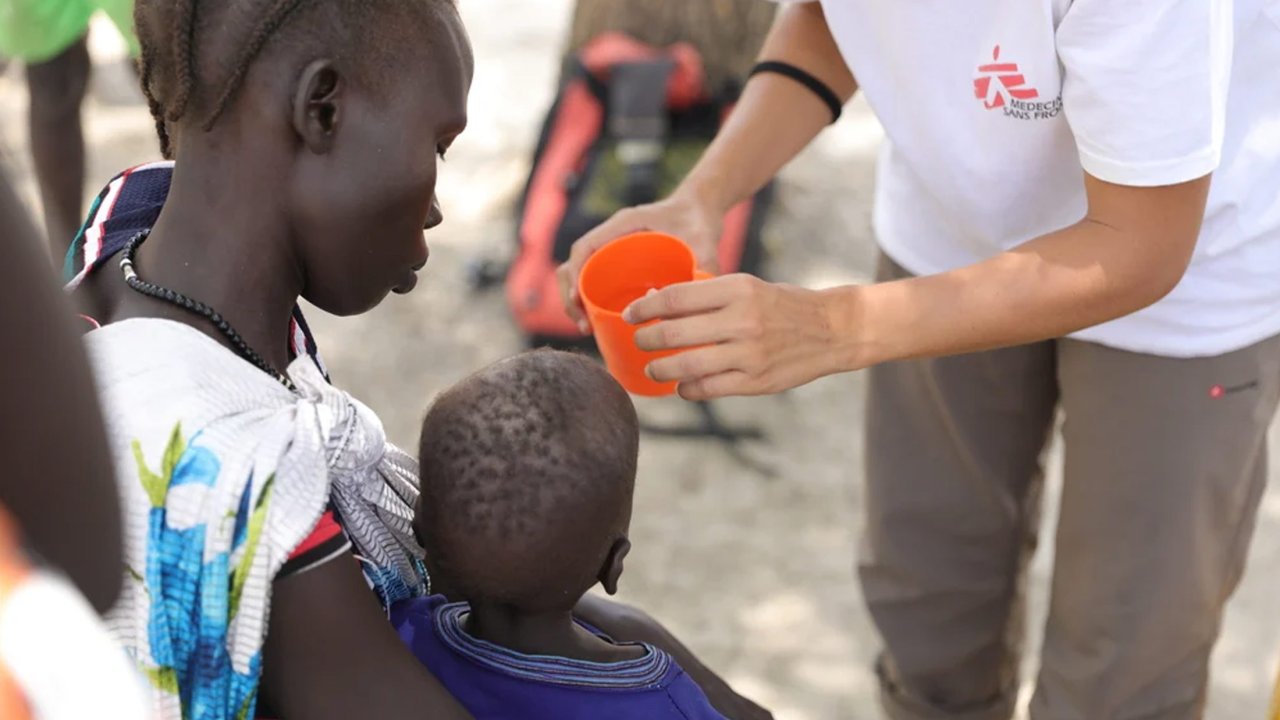 Un agent MSF apporte assistance à une femme déplacée et son enfant à Malakal. 