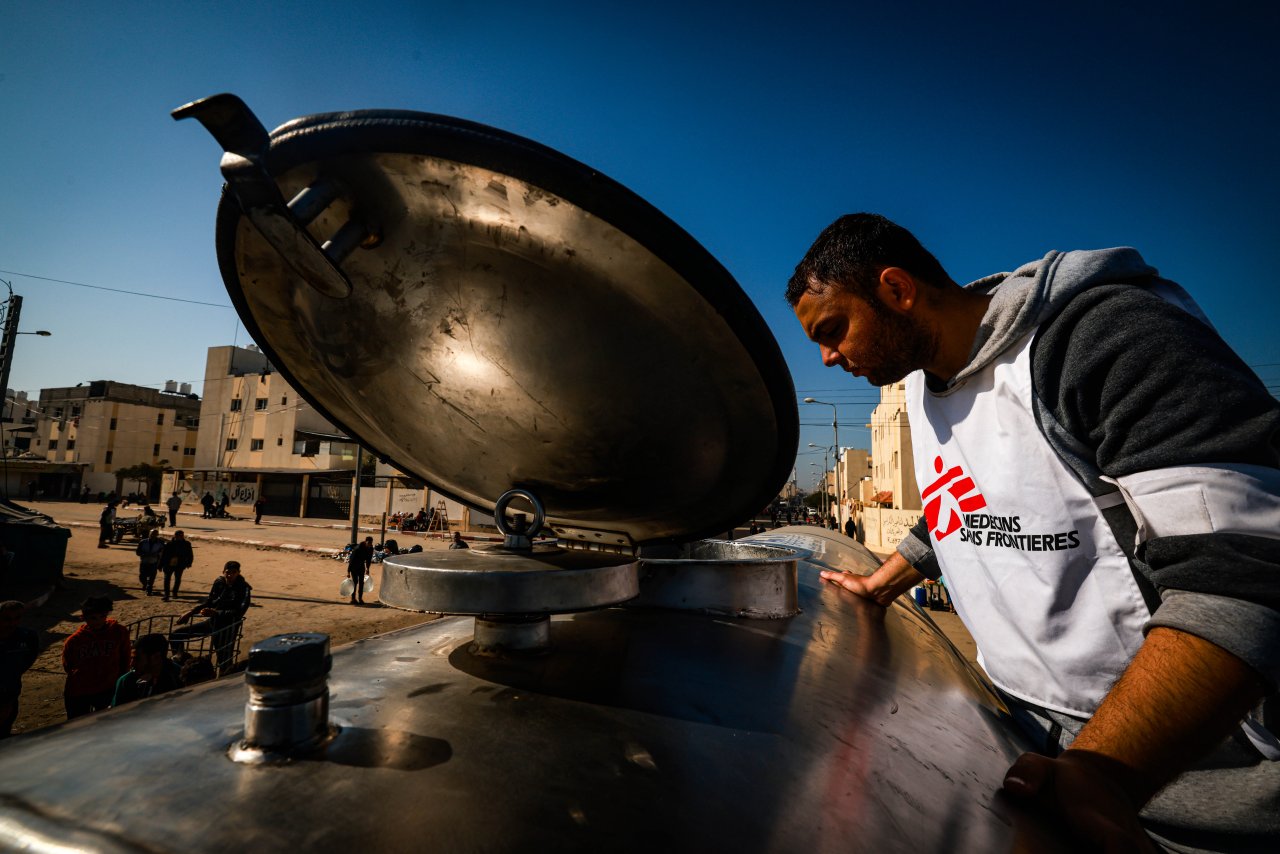 Un employé Médecins Sans Frontières distribuant de l'eau à Rafah, bande de Gaza. Aide humanitaire Gaza.