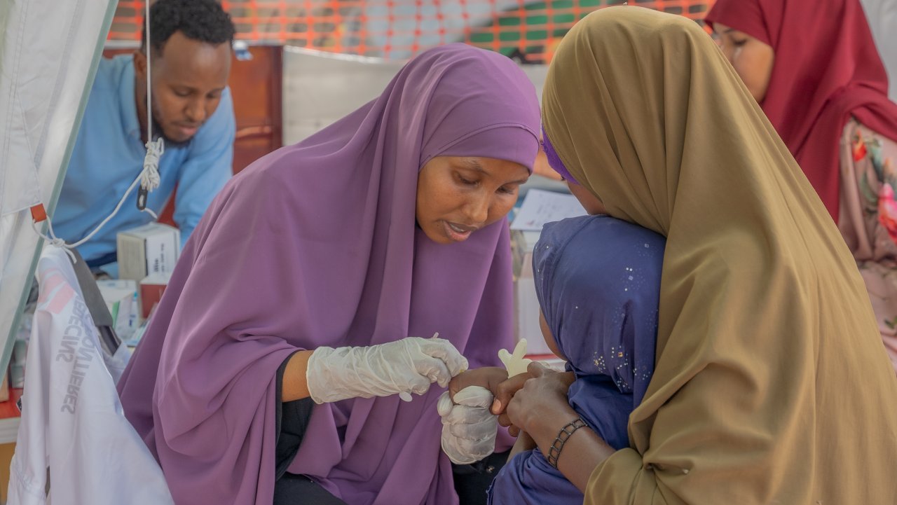 Fatuma Abdi Mohamed, MSF-Gesundheitspflegern, gibt einem Kind in der mobilen Klinik in Jaribu eine Spritze. 20. Dezember 2024.