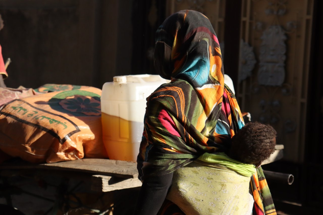 Une femme rentrant chez elle avec la nourriture qu'elle a reçu lors d'une distribution organisée par les équipes de Médecins Sans Frontières à Nyala, Sud-Darfour, Soudan.