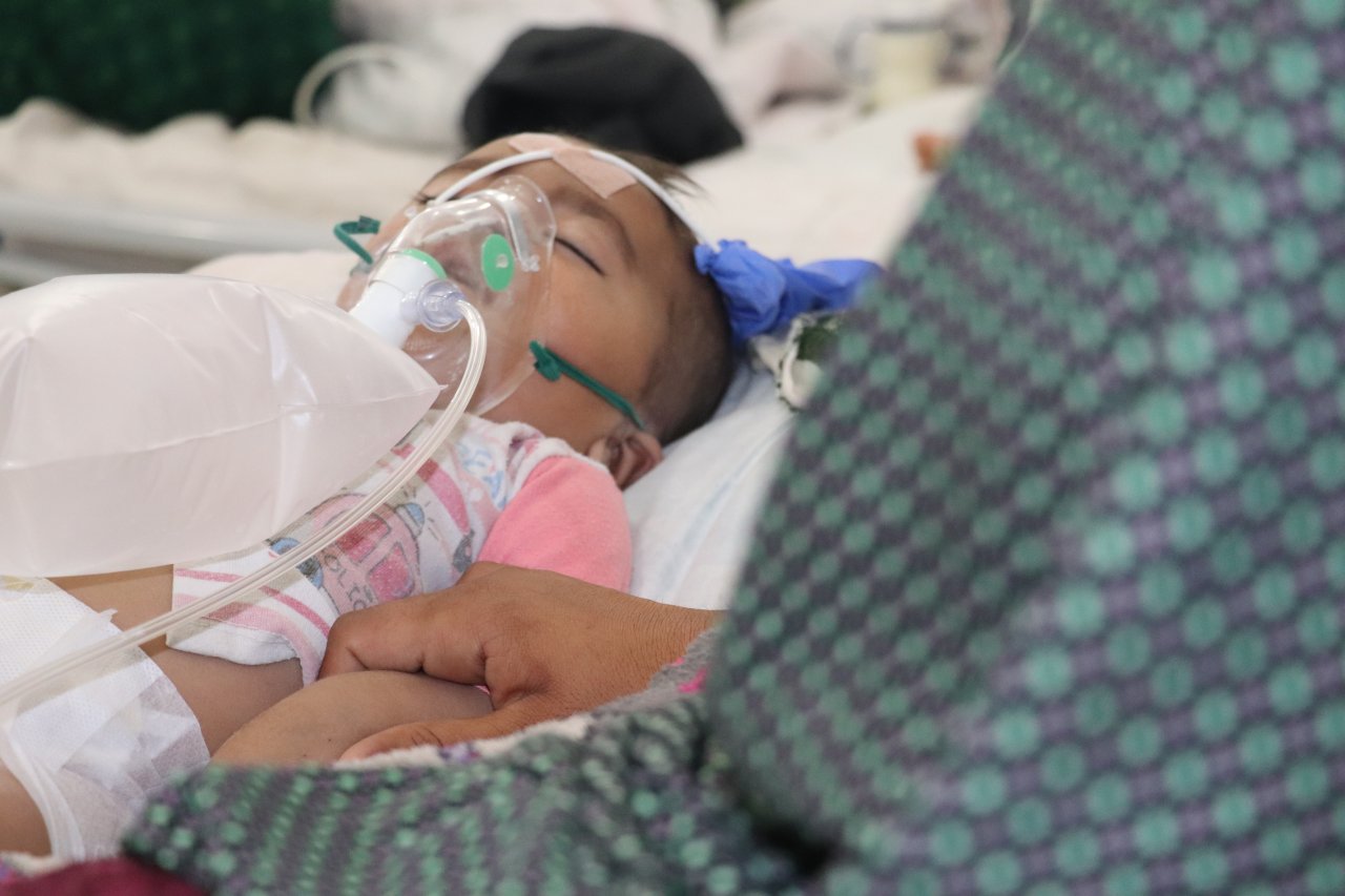 Zarmeena, 20 ans, au chevet de sa fille Asma admise en soins pédiatriques intensifs à l’hôpital de Boost.
