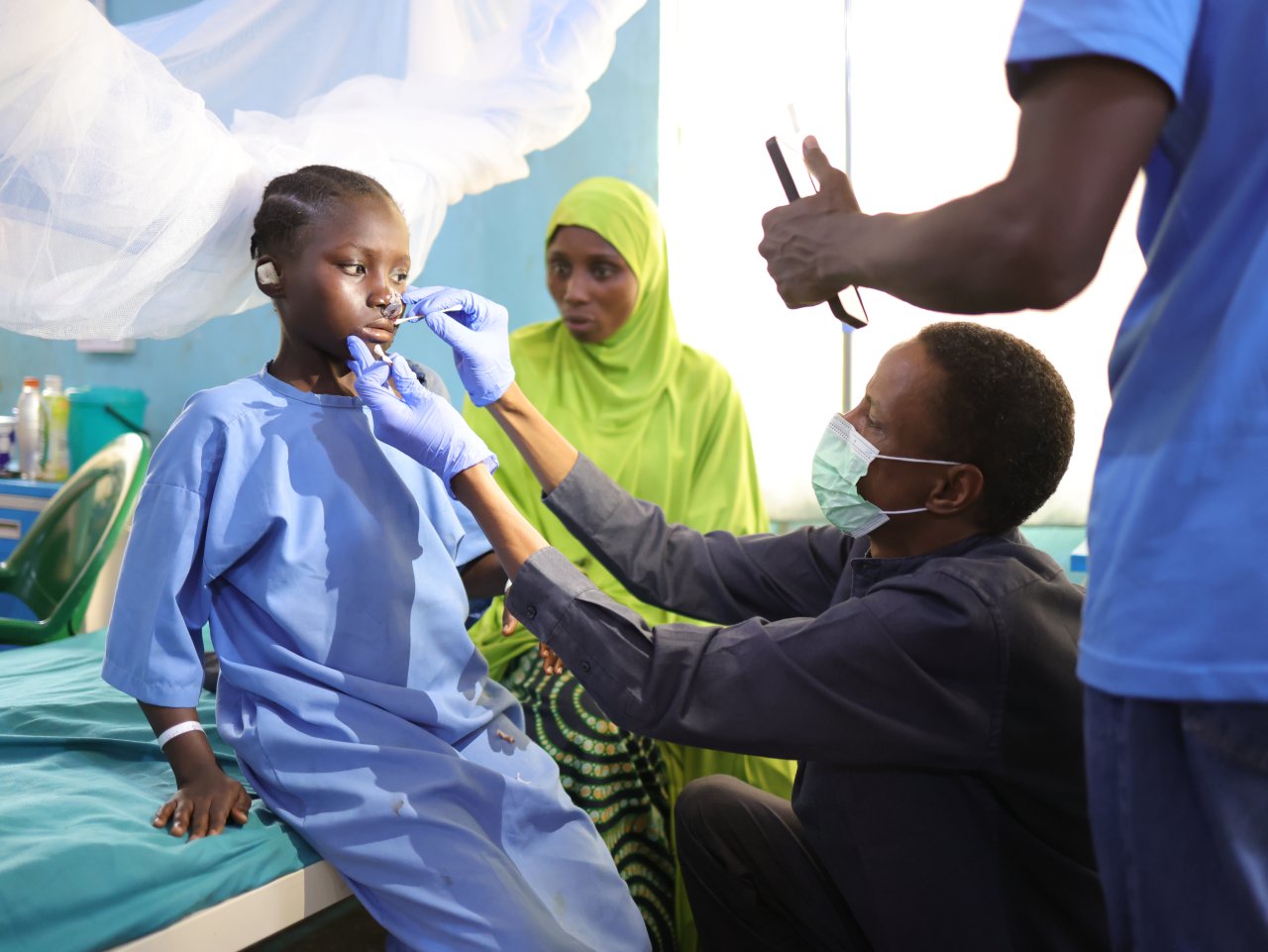 Le chirurgien du ministère de la Santé, Muhammad Abdullahi, examine Maryam Bashir, 12 ans, le lendemain de son opération reconstructive du nez à l'hôpital pour enfants Noma, soutenu par MSF, dans l'État de Sokoto, au Nigéria. 